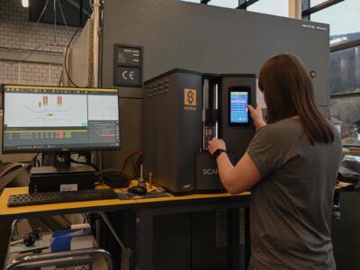 Operaria midiendo una pieza torneada con el sistema óptico Sylvac-SCAN S25 en taller de mecanizado