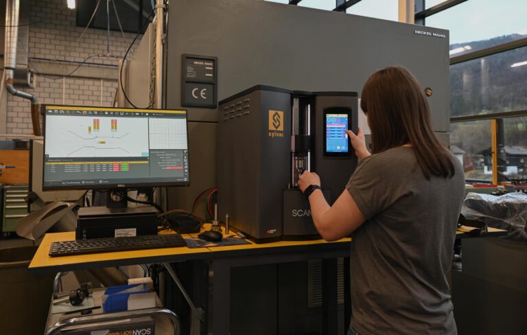 Operaria midiendo una pieza torneada con el sistema óptico Sylvac-SCAN S25 en taller de mecanizado